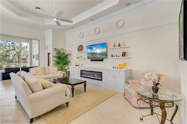 living room with a tray ceiling, ceiling fan, light tile patterned flooring, and ornamental molding