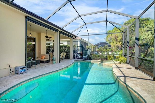 view of pool with outdoor lounge area, glass enclosure, ceiling fan, an in ground hot tub, and a patio