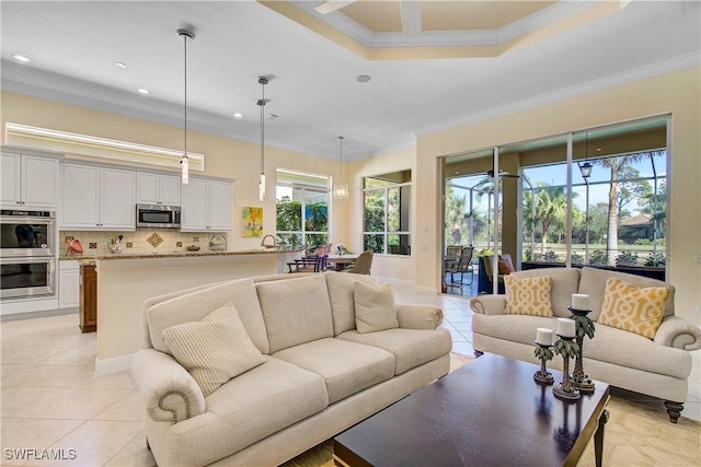 tiled living room featuring ornamental molding and a tray ceiling