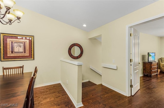 corridor with a chandelier and dark hardwood / wood-style flooring