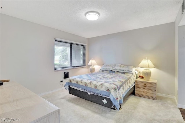 bedroom with carpet floors and a textured ceiling