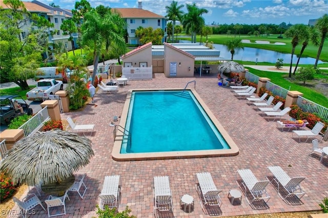 community pool with a patio, a water view, and fence