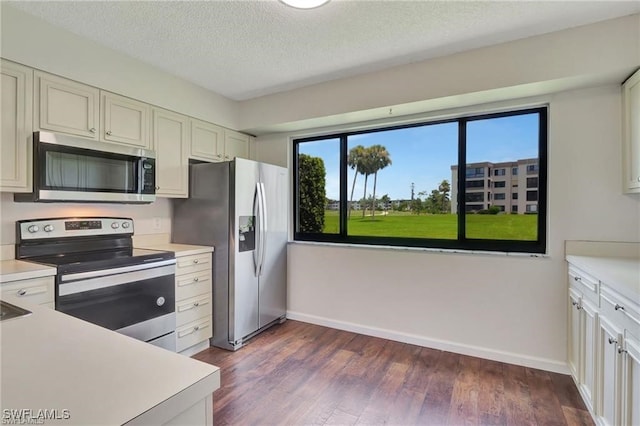 kitchen featuring appliances with stainless steel finishes, a textured ceiling, and dark hardwood / wood-style floors