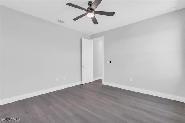 empty room with ceiling fan and dark hardwood / wood-style floors