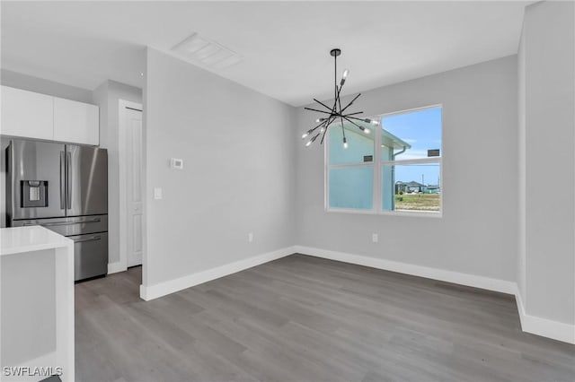 unfurnished dining area with light wood-type flooring and an inviting chandelier