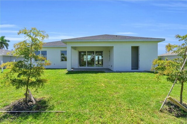 rear view of house featuring a yard