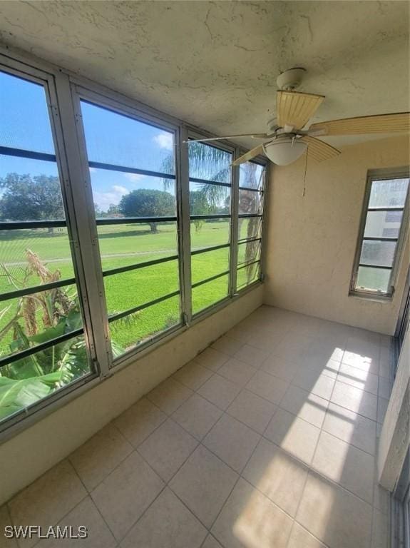 unfurnished sunroom featuring ceiling fan