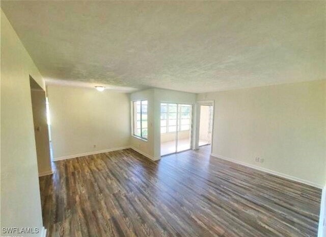 spare room with dark hardwood / wood-style flooring and a textured ceiling