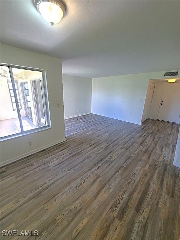 empty room with dark hardwood / wood-style floors