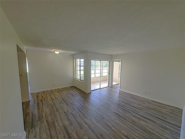 unfurnished room featuring a textured ceiling and dark hardwood / wood-style floors