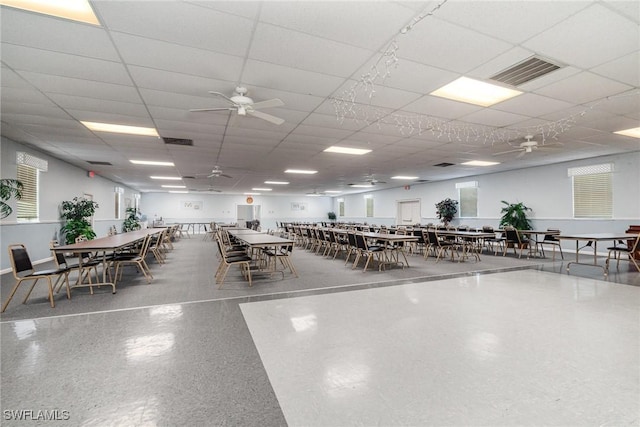 unfurnished dining area with ceiling fan and a paneled ceiling