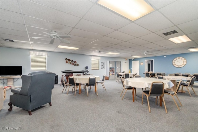 dining room featuring ceiling fan, a drop ceiling, and carpet