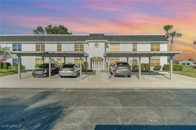 view of front of house with covered parking and roof with shingles
