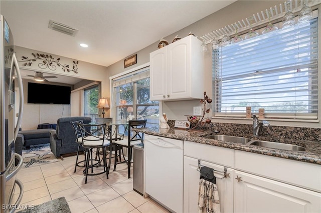 kitchen with white cabinetry, stainless steel refrigerator with ice dispenser, white dishwasher, dark stone countertops, and sink