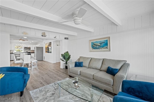 living room featuring beam ceiling and light hardwood / wood-style floors