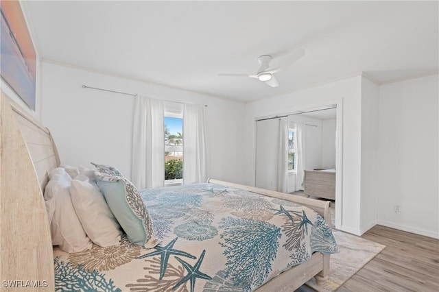 bedroom with ceiling fan, light hardwood / wood-style flooring, and a closet