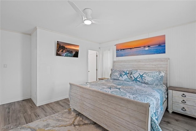 bedroom with hardwood / wood-style floors, ceiling fan, and crown molding