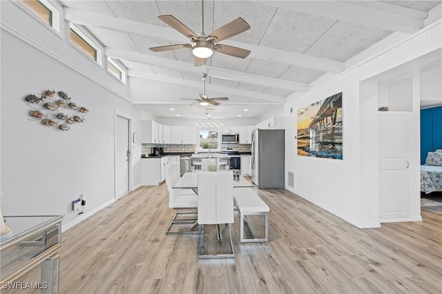 unfurnished dining area featuring lofted ceiling with beams, ceiling fan, and light wood-type flooring