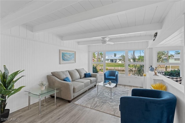 living room with ceiling fan, light hardwood / wood-style flooring, and beamed ceiling