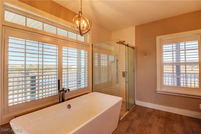 bathroom with a chandelier, independent shower and bath, and hardwood / wood-style flooring