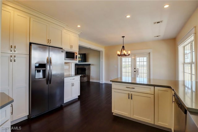 kitchen featuring french doors, stainless steel appliances, an inviting chandelier, dark hardwood / wood-style flooring, and decorative light fixtures