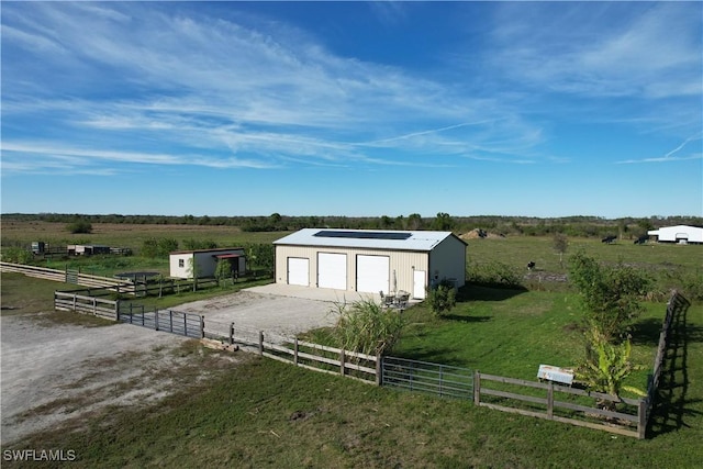 exterior space with a garage and a rural view