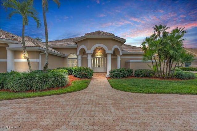 mediterranean / spanish-style house featuring a lawn