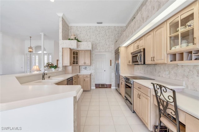 kitchen with kitchen peninsula, light brown cabinetry, stainless steel appliances, sink, and pendant lighting