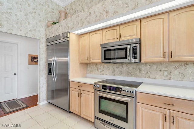 kitchen featuring light tile patterned floors, stainless steel appliances, and light brown cabinetry