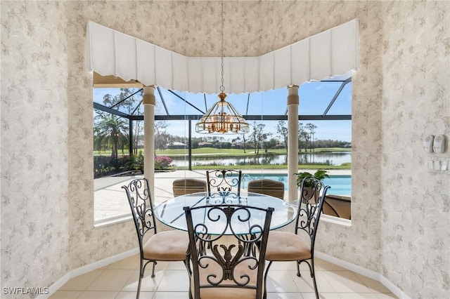 sunroom featuring plenty of natural light, a water view, and an inviting chandelier