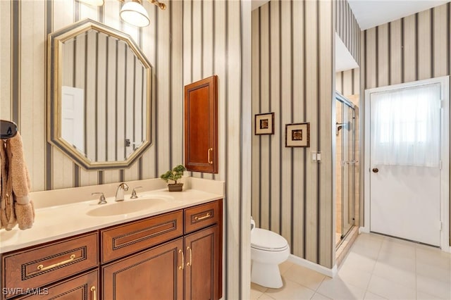 bathroom with tile patterned flooring, vanity, a shower with door, and toilet