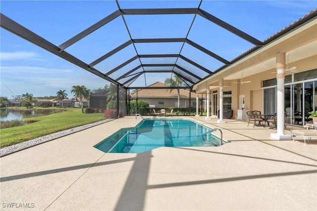 view of swimming pool with a water view, glass enclosure, ceiling fan, and a patio area