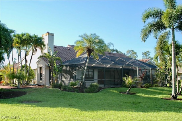 back of house with a yard and a lanai