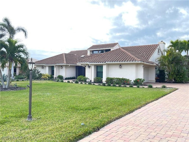 mediterranean / spanish house featuring a front lawn