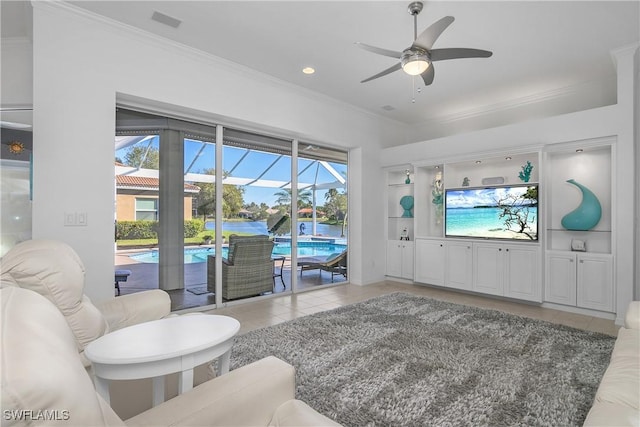 living room featuring built in shelves, tile patterned floors, ceiling fan, and a healthy amount of sunlight