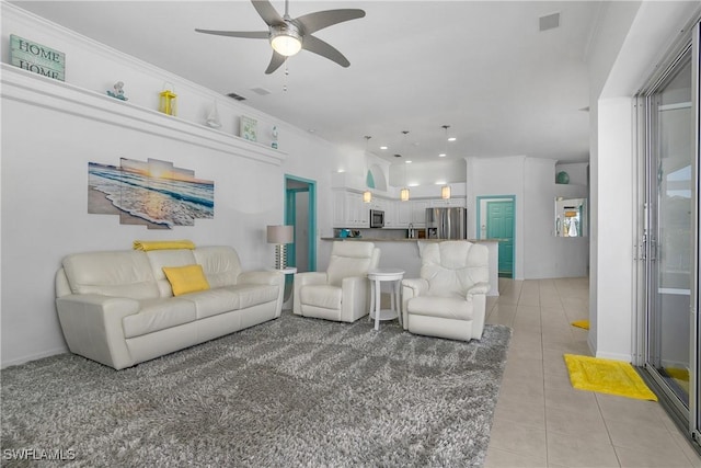 living room with ceiling fan, light tile patterned flooring, and crown molding