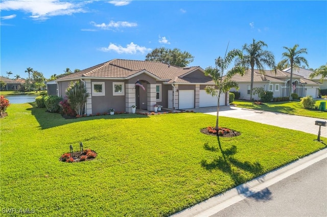 single story home with a garage, a water view, and a front lawn