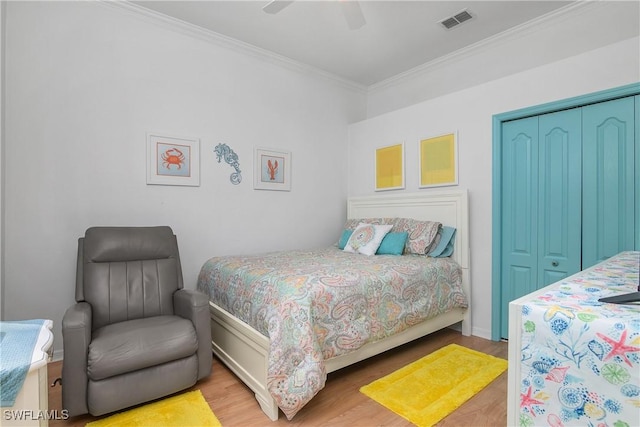 bedroom with ceiling fan, a closet, ornamental molding, and light wood-type flooring