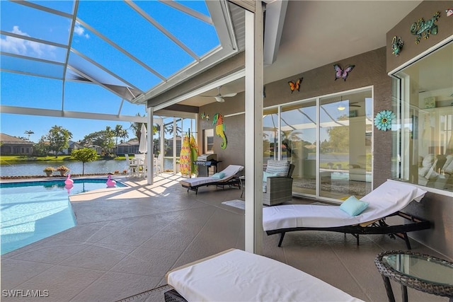 view of patio with a lanai, area for grilling, and a water view