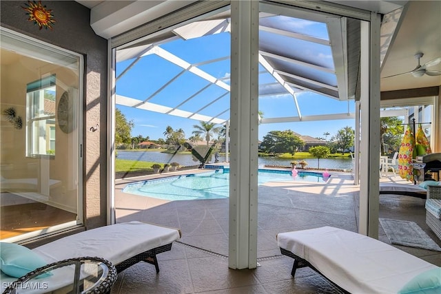 view of pool with ceiling fan and a water view