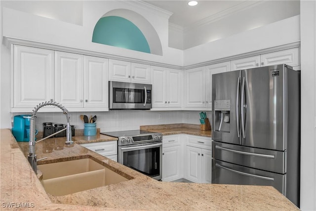 kitchen with white cabinets, sink, light stone counters, and stainless steel appliances