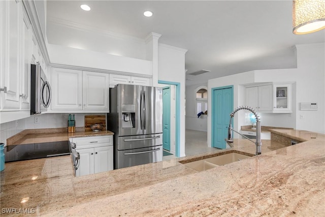 kitchen with white cabinets, sink, light stone countertops, and stainless steel appliances