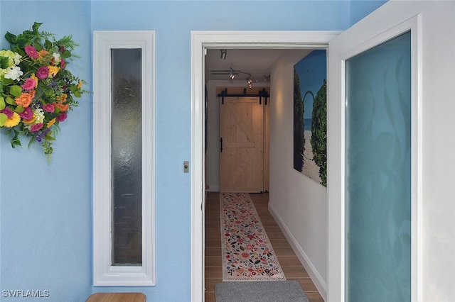 hall with a barn door and hardwood / wood-style flooring