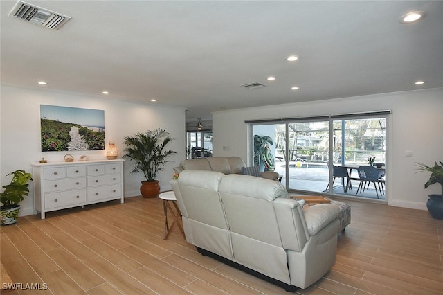 living room with light hardwood / wood-style flooring, ceiling fan, and ornamental molding