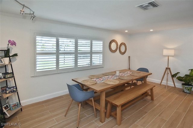 dining space with light hardwood / wood-style floors and ornamental molding