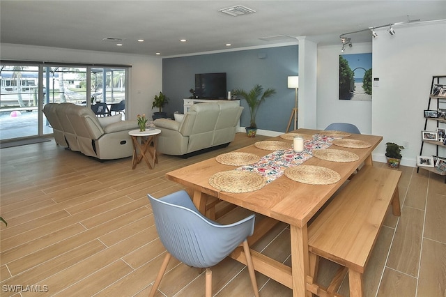 dining space with light hardwood / wood-style flooring and ornamental molding