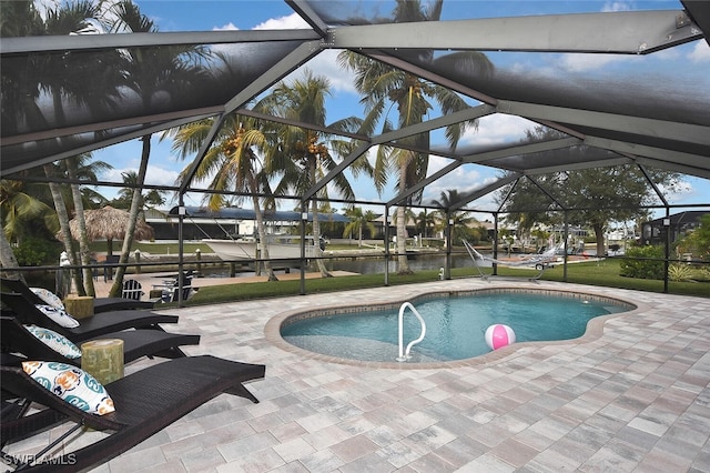 view of pool featuring a patio, a water view, and a lanai