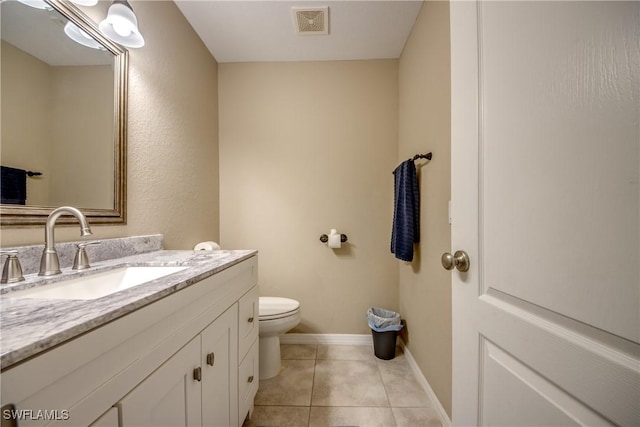 bathroom with tile patterned flooring, vanity, and toilet