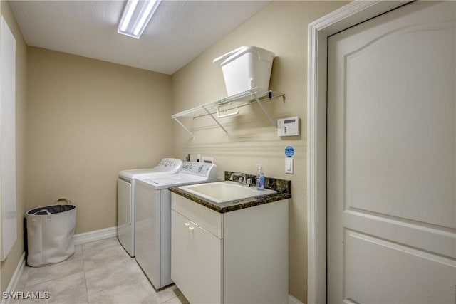 laundry room featuring cabinets, separate washer and dryer, sink, and light tile patterned floors