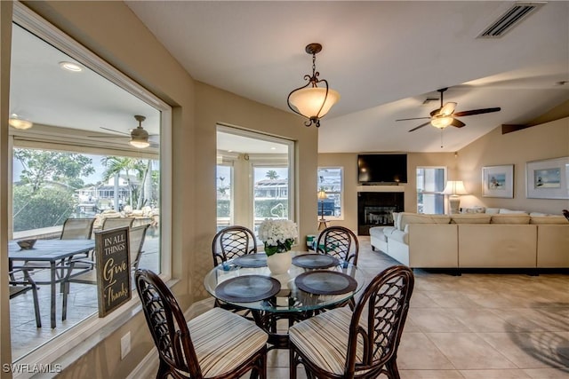 tiled dining space featuring ceiling fan and vaulted ceiling